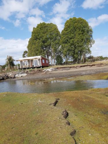 a house on the shore of a body of water at Cabaña Encanto del humedal Aituy in Aytuy