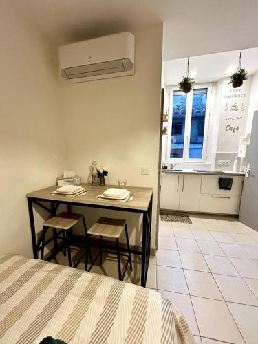 Il comprend une chambre avec une table et des chaises ainsi qu'une cuisine. dans l'établissement Le Cocon du Centre - Studio Cosy en hypercentre, à Avignon
