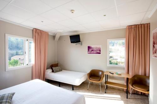Una habitación de hotel con una cama, una mesa y sillas. en Guilleumes Montserrat, en Monistrol