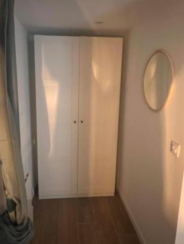 un couloir avec une porte blanche et un miroir dans l'établissement Studio indépendant et équipé proche Circuit des 24h et Pôle Européen du Cheval, à Parence