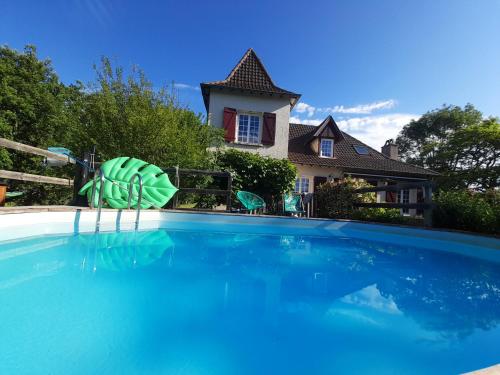 - une piscine avec un objet vert et blanc en face d'une maison dans l'établissement maison quercynoise FIGEAC, à Lunan