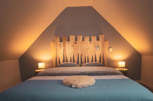 une chambre avec un grand lit avec une tête de lit en bois dans l'établissement Les cigognes gites de la reserve, à Grand-Laviers
