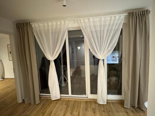 a room with white curtains and a large window at S4 FeWo in Bad Saarow, Seestr 4a in Bad Saarow