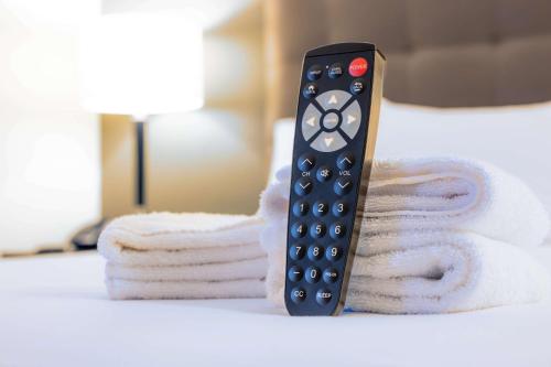 a remote control sitting on top of a pile of towels at Drury Inn & Suites San Antonio Near La Cantera in San Antonio