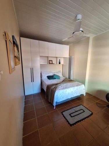 a bedroom with a bed and white cabinets and a tile floor at Recanto do Saldanha in Angra dos Reis
