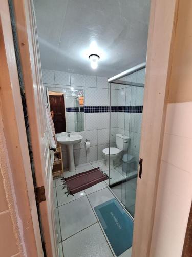 a bathroom with a sink and a toilet and a mirror at Recanto do Saldanha in Angra dos Reis