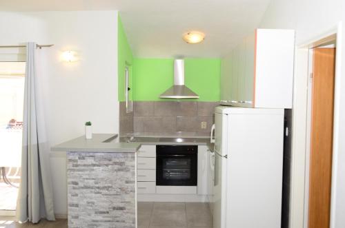 a kitchen with a stove and a refrigerator at Apartments Vodanović in Podgora