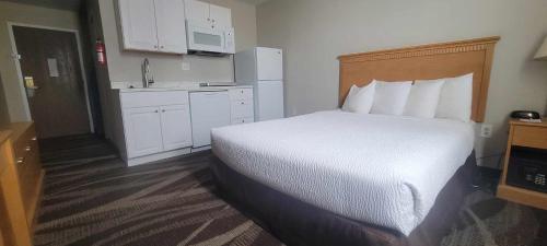 a hotel room with a bed and a kitchen at Days Inn by Wyndham Gillette in Gillette