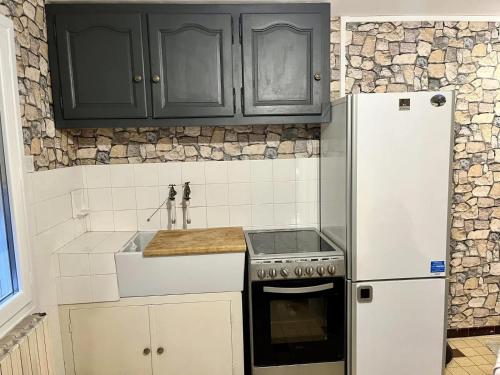 - une cuisine avec des armoires noires et un réfrigérateur blanc dans l'établissement Charming independent studio, à Ruelle-sur-Touvre