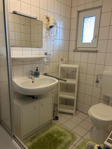 a bathroom with a sink and a toilet at Haus Mariechen in Hooksiel