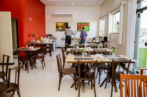 a restaurant with tables and people in the background at Hotel Oceania in Eunápolis