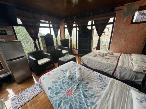 a bedroom with two beds and a chair at Hanna Suites in Panajachel