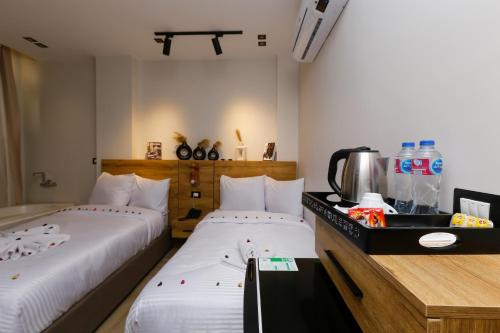 a room with two beds and a counter with at Rixoss Tower Pyramids View in Cairo