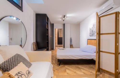 une chambre avec deux lits et un miroir dans l'établissement Appartement détente avec jacuzzi et piscine, à Perpignan
