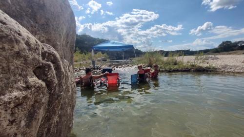 a group of people sitting in the water at Boulderdash Cabin in Bandera