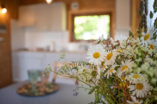 a vase of flowers on a table in a kitchen at Chatki Szymonówko in Szymonówko