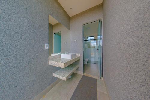 a bathroom with a sink and a mirror at Espaço premium, Casa com 5 quartos, piscina aquecida & Jacuzzi in Caldas Novas