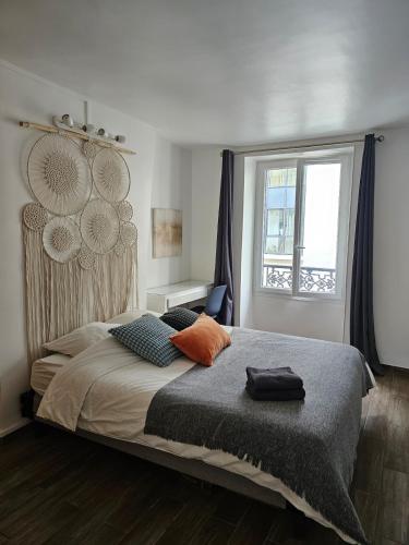 une chambre avec un grand lit et une fenêtre dans l'établissement Apt at stlazarre opera haussman, à Paris