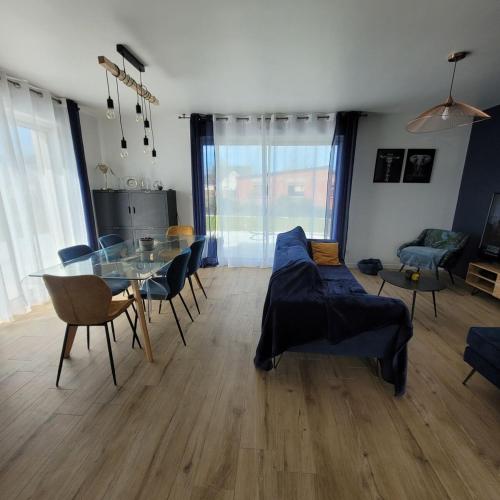 un salon avec une table en verre et des chaises dans l'établissement Pavillon neuf CREANCES plage, à Créances