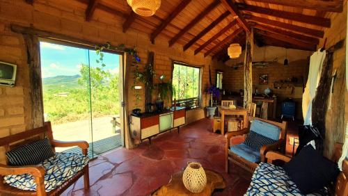 a living room with a large window in a cabin at Ecopousada Toca do Guará in Alto Paraíso de Goiás