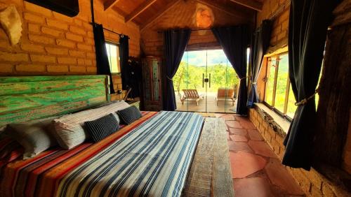 a large bed in a room with a window at Ecopousada Toca do Guará in Alto Paraíso de Goiás
