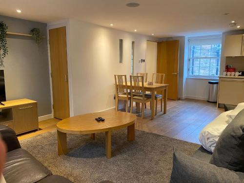 a living room with a table and a dining room at CS Exclusive Apartments of Princess Street West End in Edinburgh