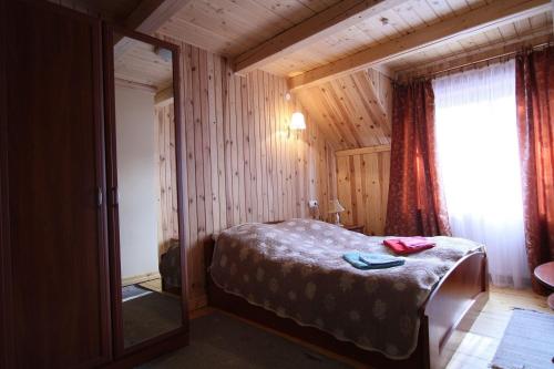 um quarto com uma cama num quarto com paredes de madeira em Blizzard em Slavske