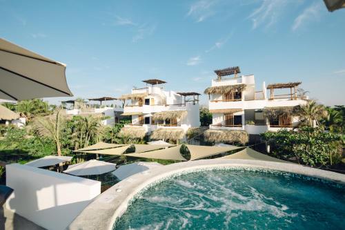 a resort with a swimming pool and a building at Ka´ana Surf in El Paredón Buena Vista