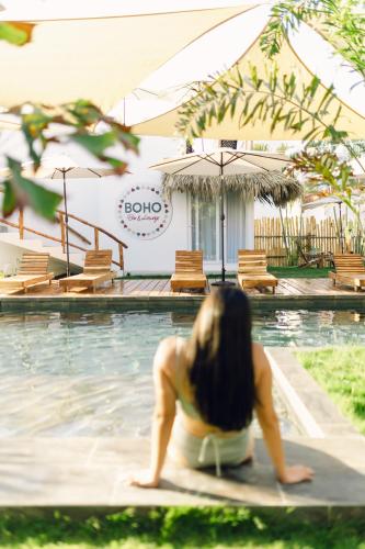 a woman sitting on a surfboard in a swimming pool at Ka´ana Surf in El Paredón Buena Vista