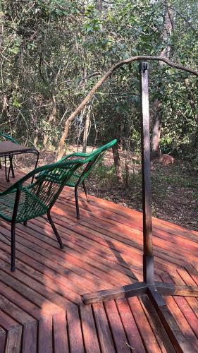 a green bench sitting on a wooden deck at San Bernardino,8vientos cabaña in San Bernardino