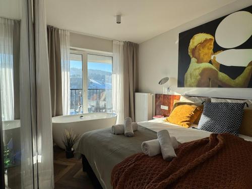 een slaapkamer met een groot bed en een bad bij Widok Marzeń Sun&Ski Romantic Art House z garażem in Krynica Zdrój