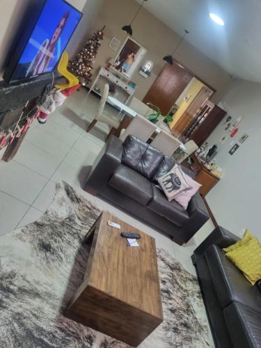 a living room with a couch and a coffee table at Hospedagem Sil e Jean quarto triplo, cozinha compartilhada com outros hóspedes in São Gabriel