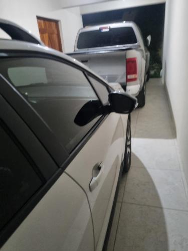 a white car is parked in a garage at Hospedagem Sil e Jean quarto triplo, cozinha compartilhada com outros hóspedes in São Gabriel