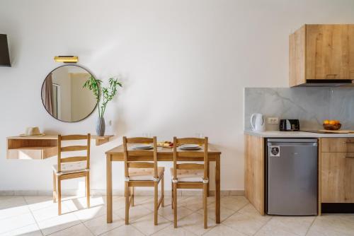 a kitchen with a table and chairs and a mirror at Eagle's Nest in Lourdhata