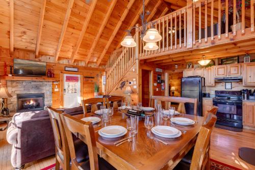 a dining room with a wooden table and a kitchen at Thistle Britches, Secluded Mountain Cabin with Stunning Mountain Views, 1 Acre Next to Dollywood, Hot Tub, Pet Friendly in Sevierville