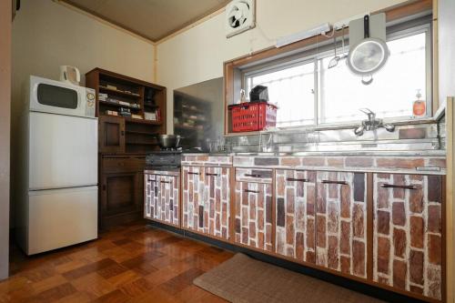 a kitchen with a white refrigerator and a window at アウトドアアトラクション北軽井沢 in Tsumagoi