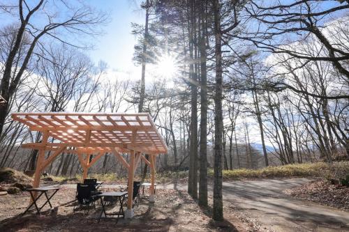 a wooden pavilion in the middle of a forest at アウトドアアトラクション北軽井沢 in Tsumagoi