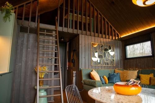 a room with a loft bed and a table and a couch at Inarden Yellowstone Cabin in Durbuy