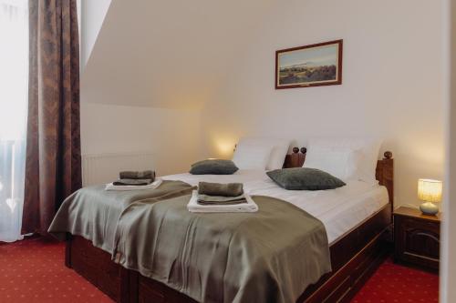 a bedroom with a bed with two pillows on it at Pensiunea Csató Borzont - Csató Panzió Borzont in Borzont