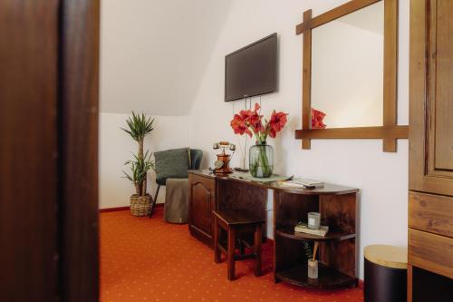 a room with a desk with a television on a wall at Pensiunea Csató Borzont - Csató Panzió Borzont in Borzont