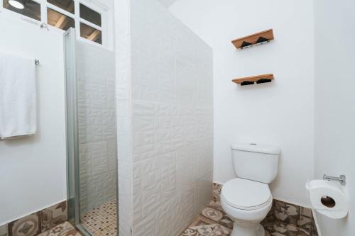 a white bathroom with a toilet and a shower at Villa Marina Lodge & Condos in Playa Venao