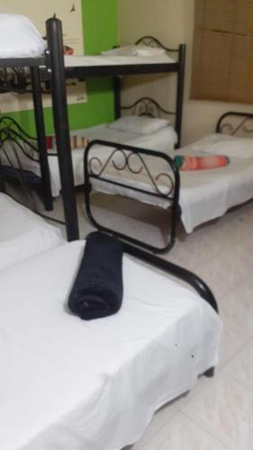 a room with three bunk beds with a hat on them at Finca Turistica VillaMaria in Tena