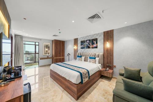 バンガロールにあるHotel Grand Kasturiのベッドとリビングルームのある寝室
