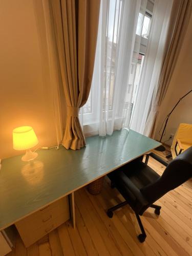 a desk with a lamp and a chair in front of a window at Florence family 2BDR Apt - min from Serdika w WiFi in Sofia
