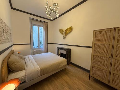 a bedroom with a bed and a chandelier at Suite Marguerite - Haussmannien chic hyper centre in Angers