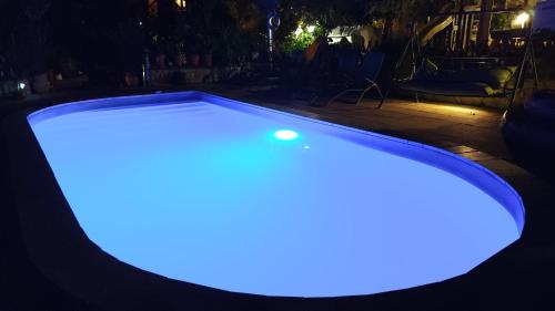 a pool with a blue light in the dark at Katica Vendégház in Siófok