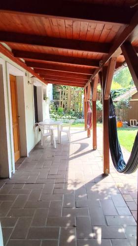 an outdoor patio with a hammock and a table at Katica Vendégház in Siófok
