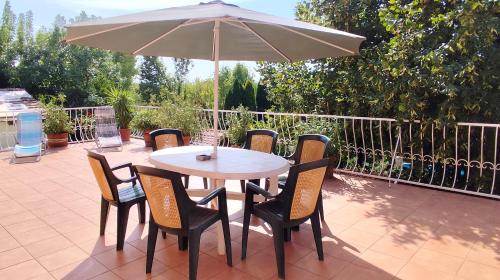 a table and chairs with an umbrella on a patio at Katica Vendégház in Siófok