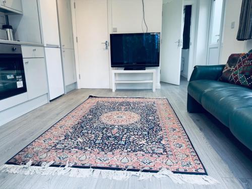 a living room with a couch and a rug at A cozy apartment in Windsor