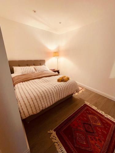 a bedroom with a bed and a red rug at A cozy apartment in Windsor